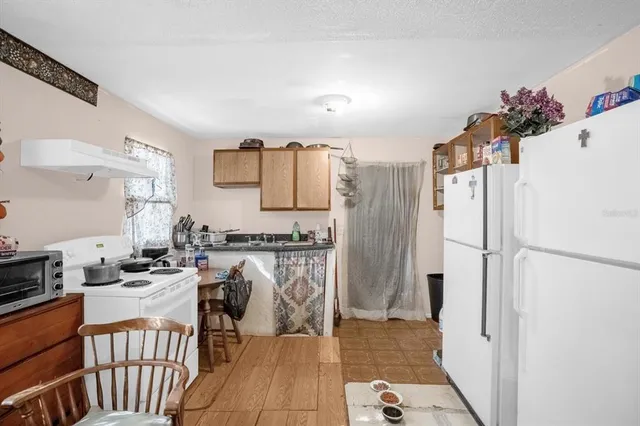 a kitchen with stainless steel appliances granite countertop a refrigerator and a stove top oven