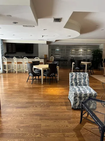 a living room with furniture a flat screen tv and kitchen view