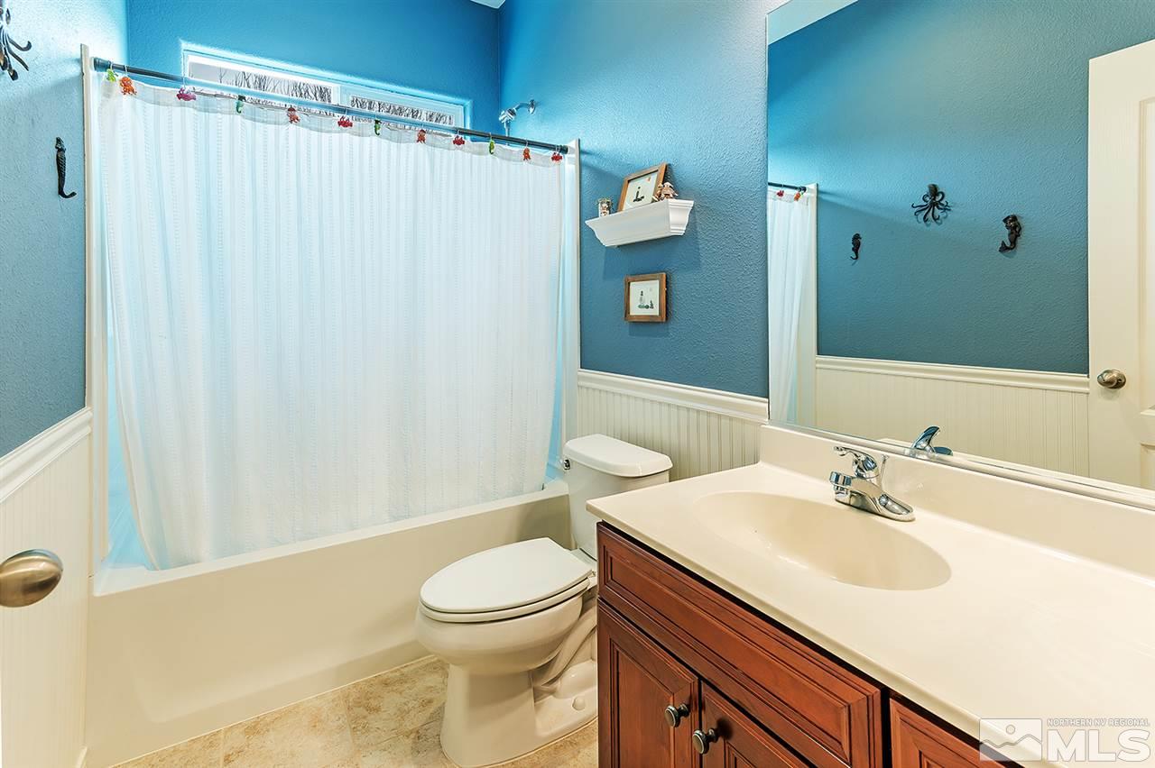 395 Sondrio Way Reno, NV 89521 - Photo 19 of 25 a bathroom with a sink a toilet and shower curtain