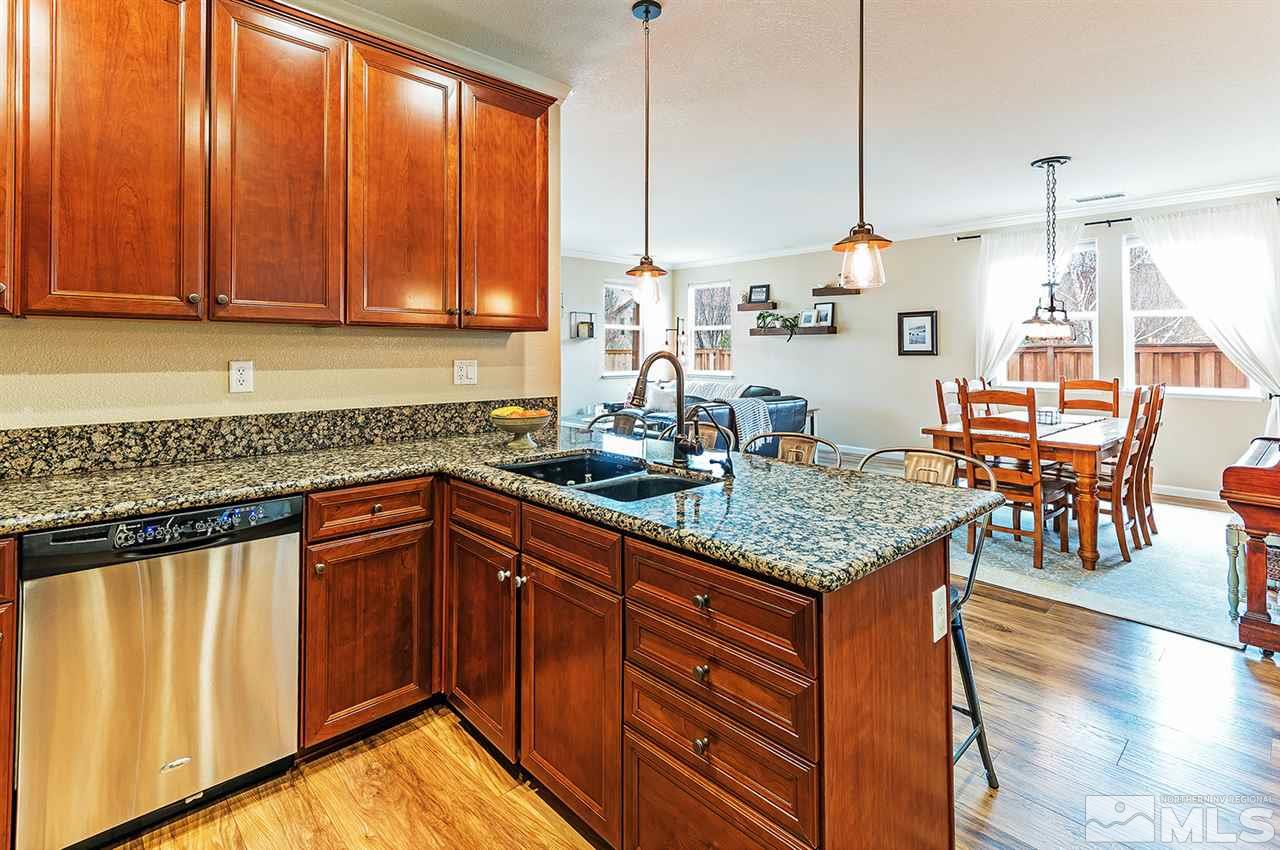 395 Sondrio Way Reno, NV 89521 - Photo 10 of 25 a kitchen with stainless steel appliances granite countertop wooden cabinets a sink and dishwasher