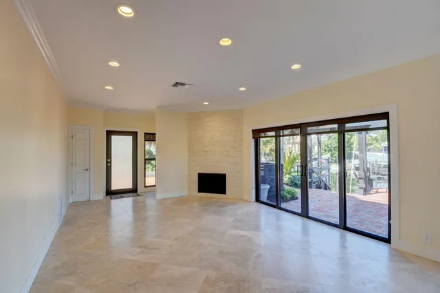 an empty room with large windows and a ceiling fan