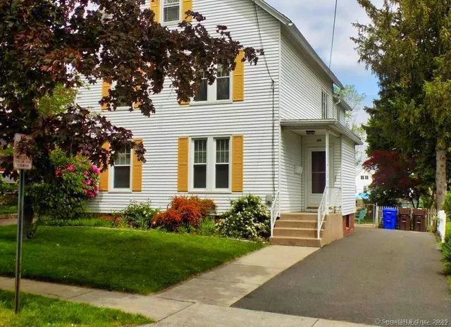 a front view of a house with a garden and plants