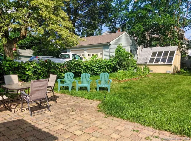 a view of a house with backyard sitting area and garden