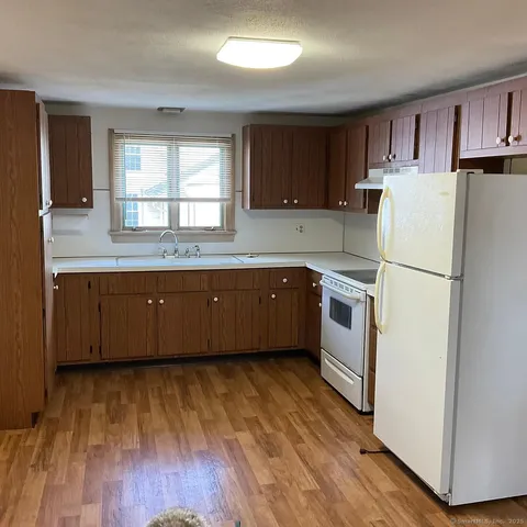 a kitchen with wooden floors and white appliances