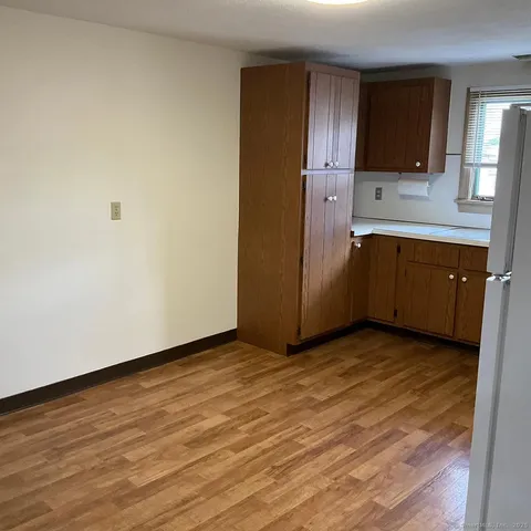 a view of a kitchen with wooden floor and electronic appliances