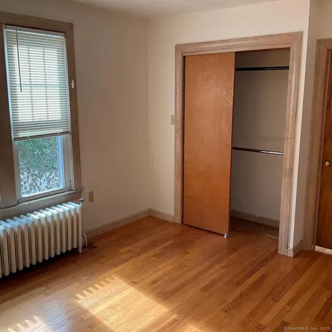 an empty room with window and wooden floor