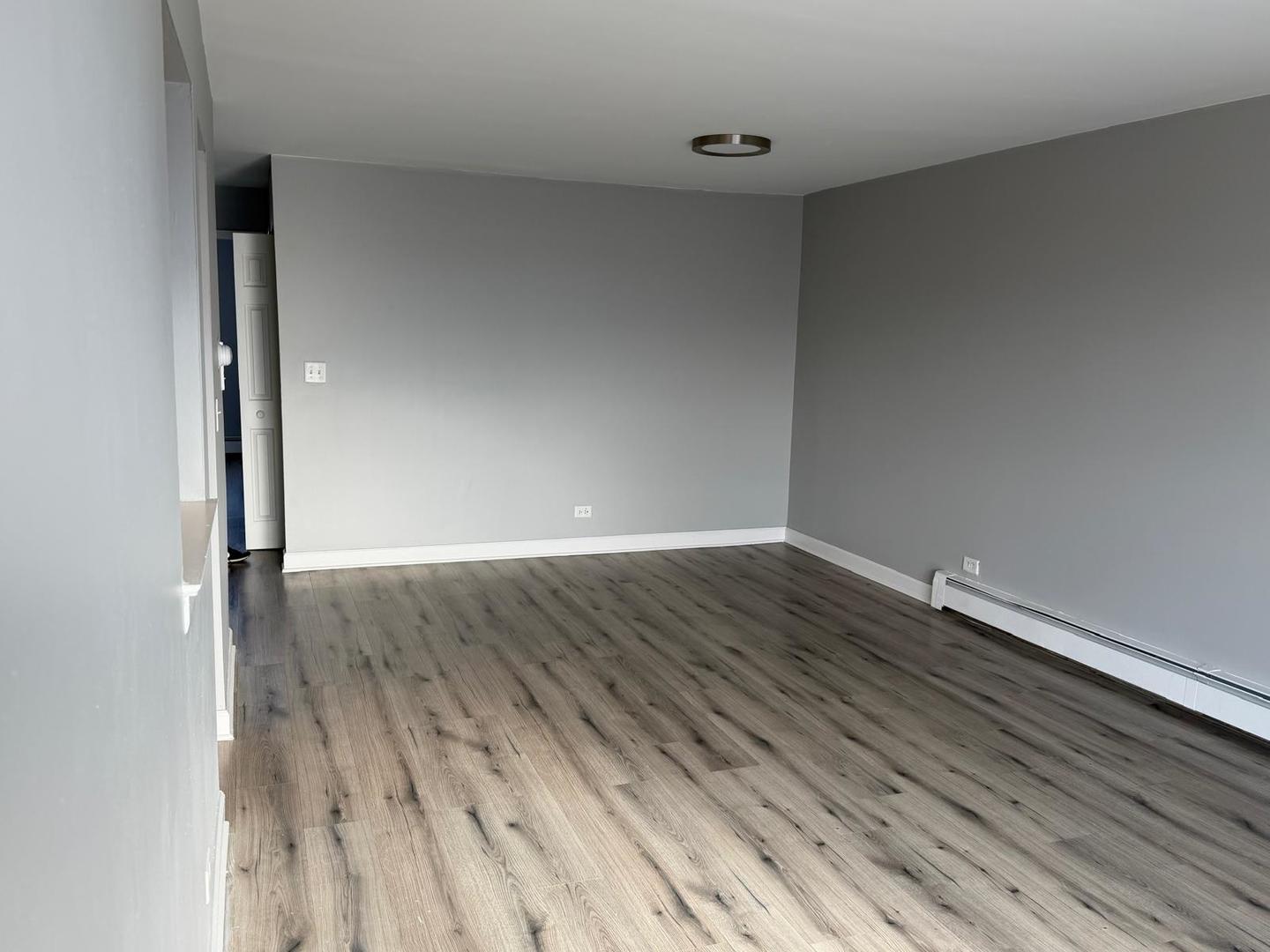 157 North Gregory Street, Unit 14 Aurora, IL 60504 - Photo 7 of 15 a view of an empty room with wooden floor