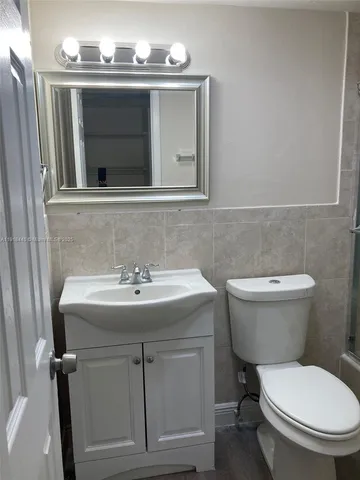a white toilet sitting next to a bath tub