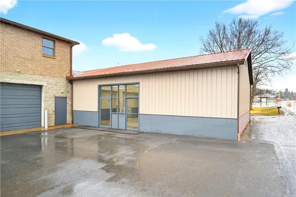 a view of an house with backyard and parking area