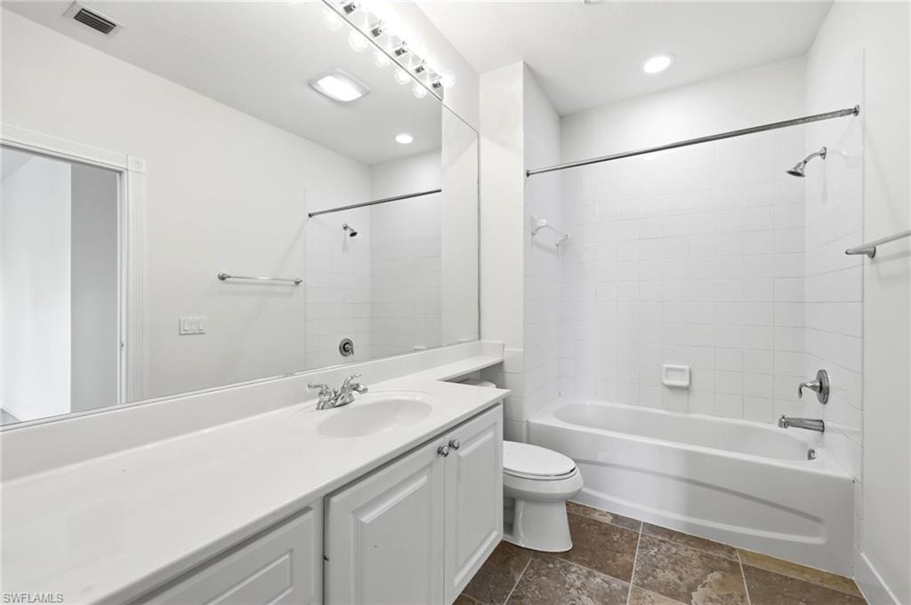 8108 Josefa Way Naples, FL 34114 - Photo 14 of 49 Full bath with vanity, dark stone finish flooring, and shower combination