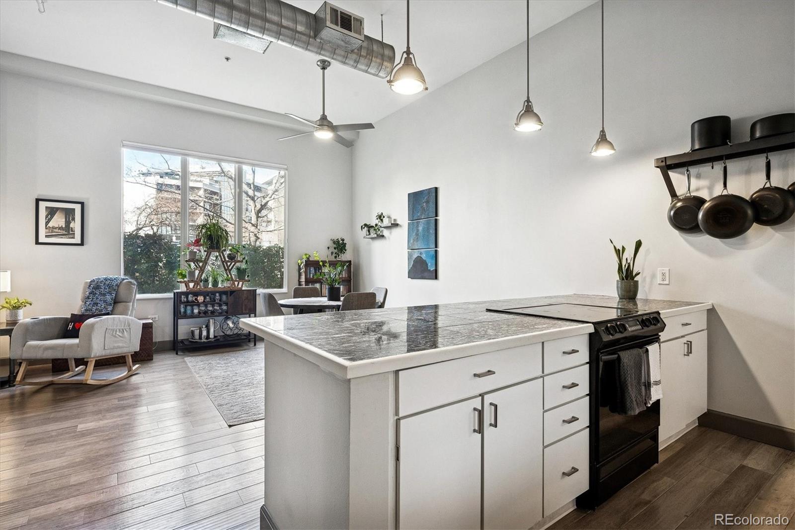 1521 Central Street, Unit 1D Denver, CO 80211 - Photo 4 of 27 a open kitchen with stainless steel appliances granite countertop a lot of white cabinets and wooden floor
