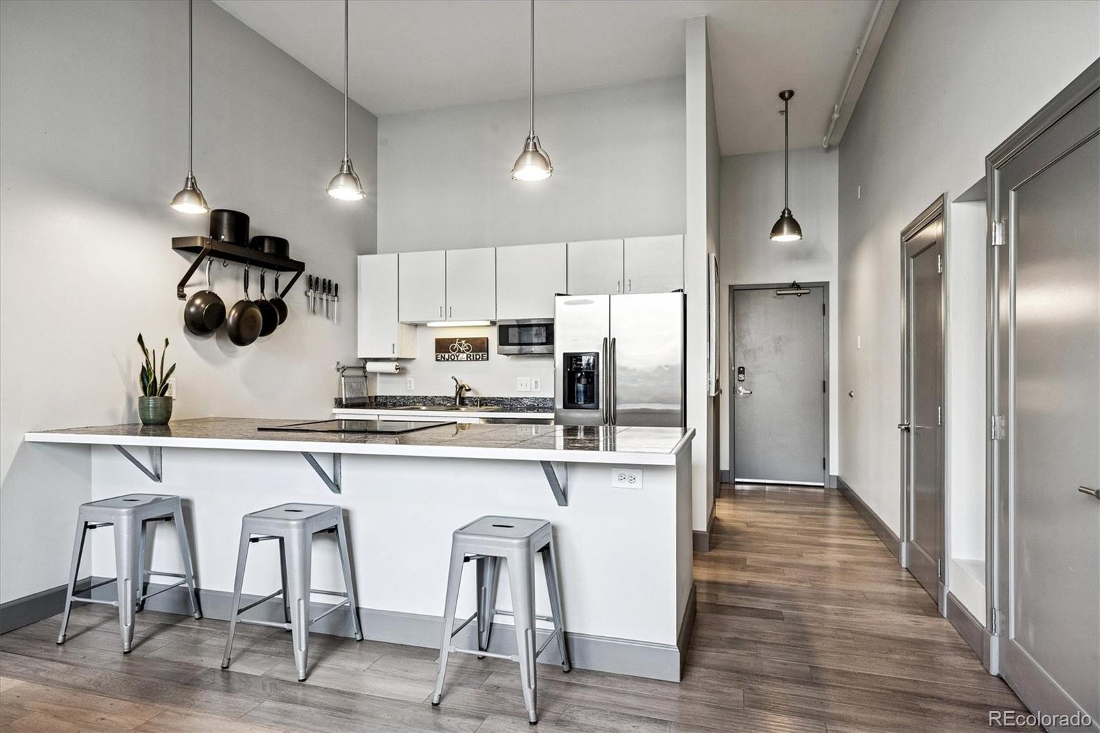 1521 Central Street, Unit 1D Denver, CO 80211 - Photo 6 of 27 a kitchen with refrigerator and chairs