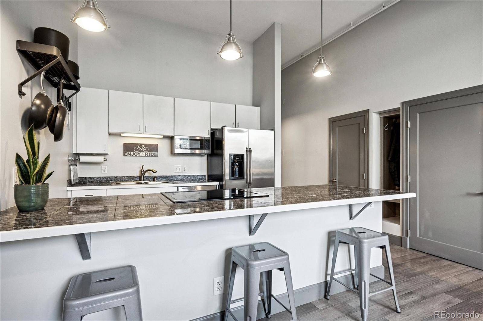 1521 Central Street, Unit 1D Denver, CO 80211 - Photo 7 of 27 a kitchen with stainless steel appliances granite countertop a sink and a refrigerator