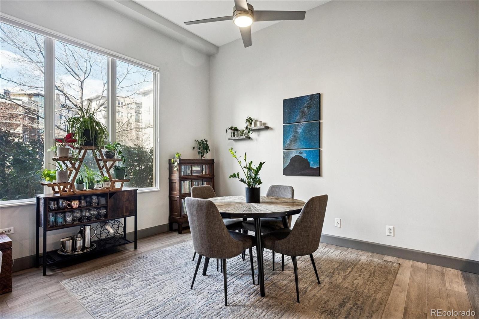 1521 Central Street, Unit 1D Denver, CO 80211 - Photo 8 of 27 a dining room with furniture potted plants and wooden floor
