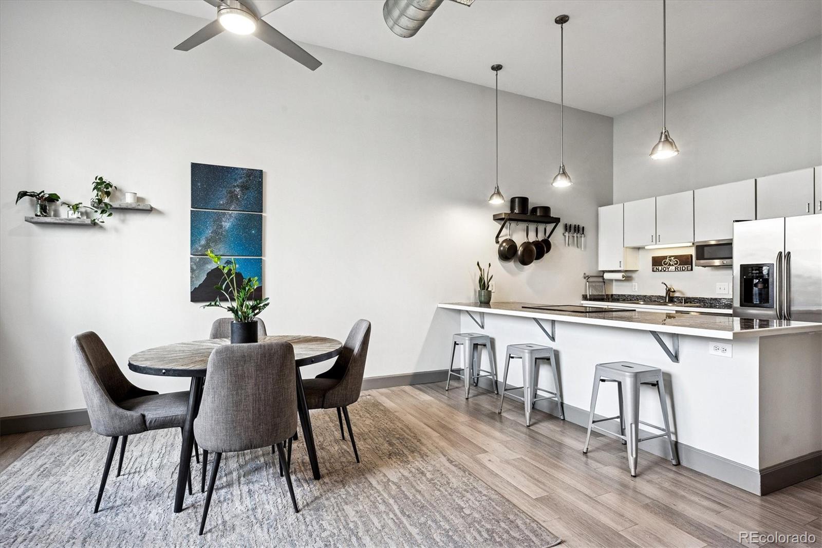 1521 Central Street, Unit 1D Denver, CO 80211 - Photo 9 of 27 a kitchen with stainless steel appliances granite countertop a dining table chairs stove refrigerator and cabinets