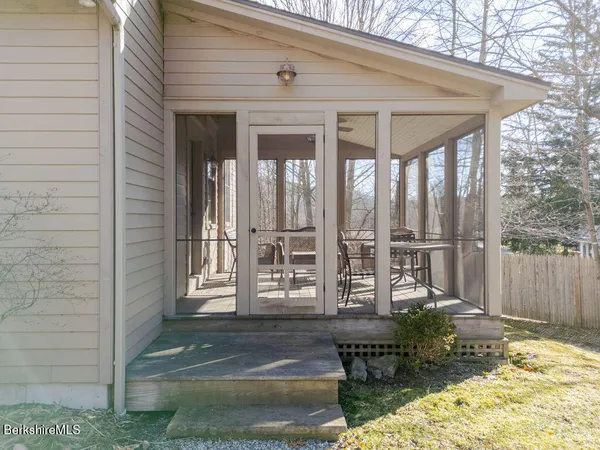 a view of a patio with table and chairs and wooden fence