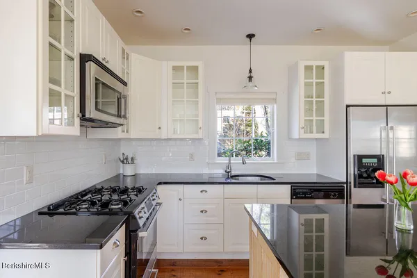a kitchen with stainless steel appliances a sink stove and cabinets