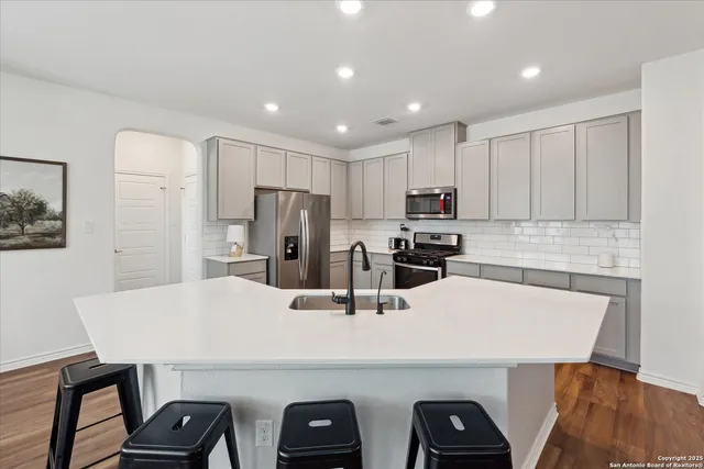 a kitchen with kitchen island a refrigerator sink and stove