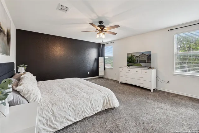 a bedroom with a bed and a flat tv screen on dresser
