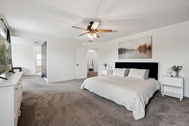 a spacious bedroom with a bed and a chandelier