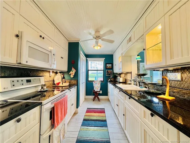 a living room with dining table and a chandelier
