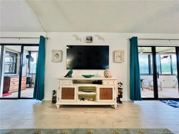 a view of a living room with furniture and floor to ceiling window