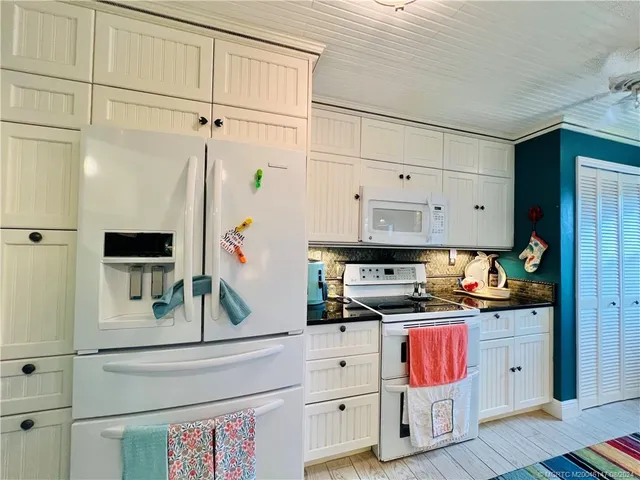 a kitchen with kitchen island granite countertop a sink cabinets and window