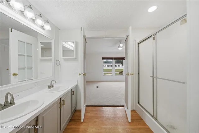 a spacious bathroom with a shower sink and mirror