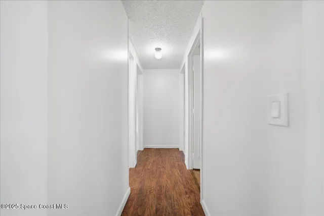 a view of hallway with wooden floor