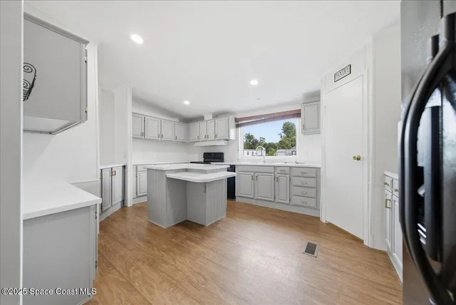 a kitchen with a sink cabinets stainless steel appliances and a window