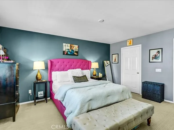 a bedroom with a bed and a refrigerator