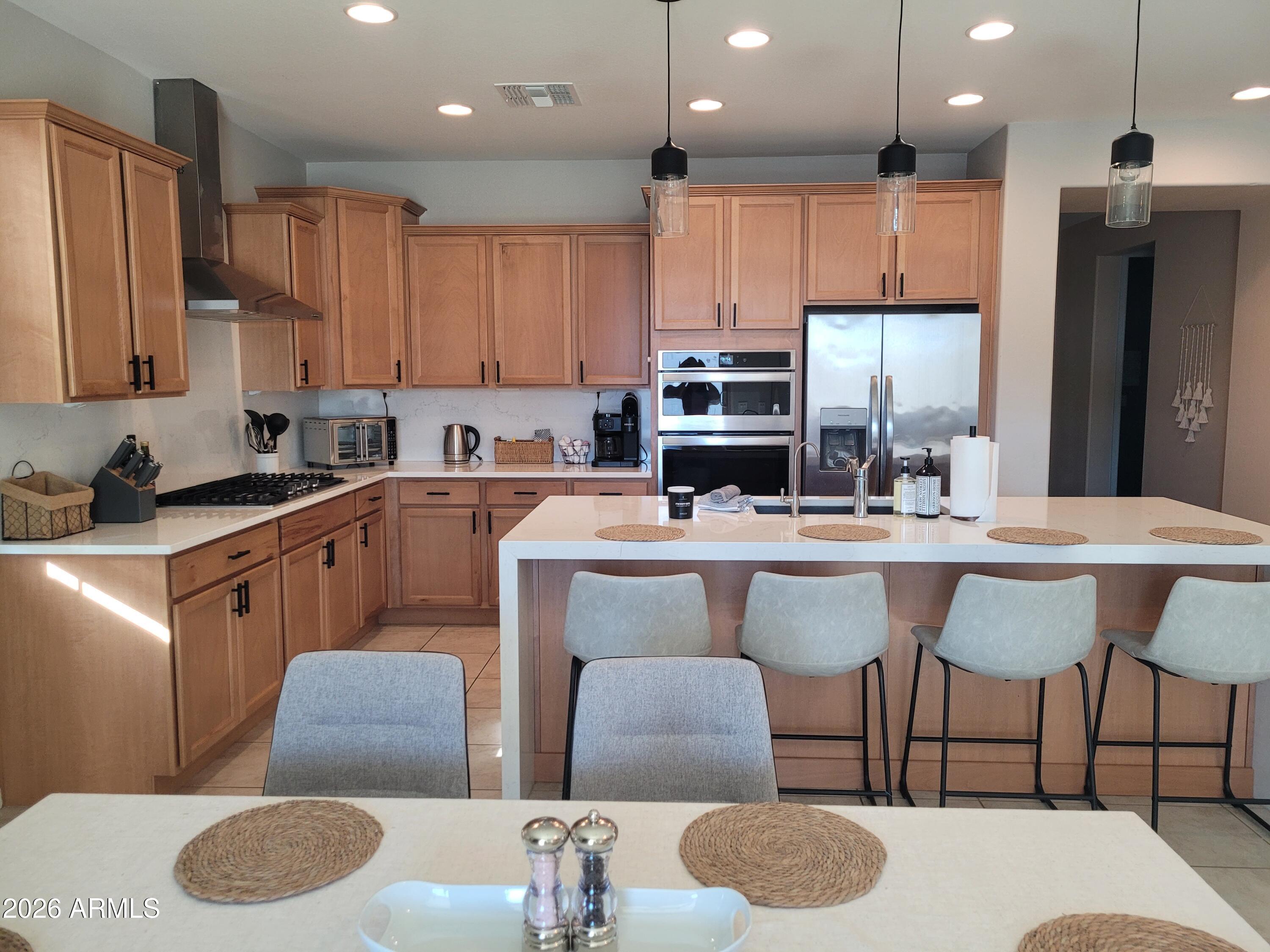 22849 East Marsh Road Queen Creek, AZ 85142 - Photo 11 of 38 a kitchen with stainless steel appliances granite countertop a table chairs sink refrigerator and microwave