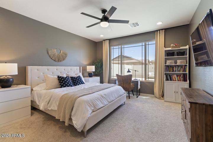 22849 East Marsh Road Queen Creek, AZ 85142 - Photo 18 of 38 a bedroom with a large bed and a chandelier