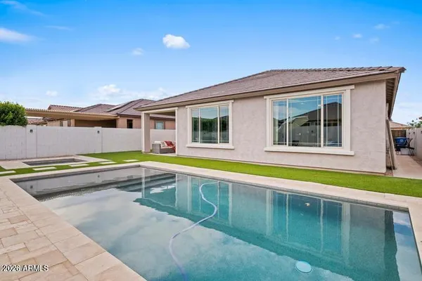 a view of a house with a swimming pool and a yard