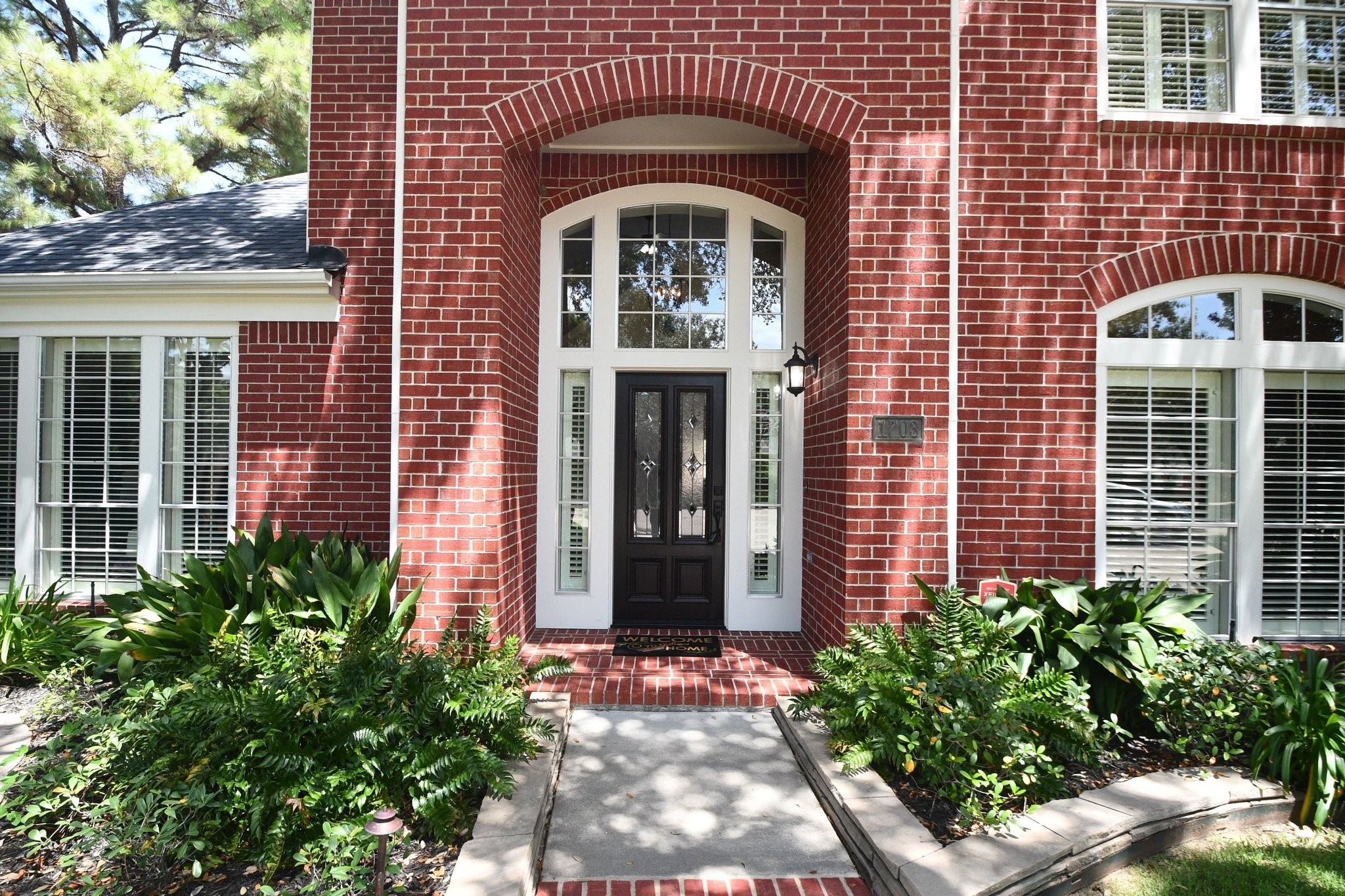 1703 Fall Ridge Circle Katy, TX 77494 - Photo 2 of 38 Guests are welcomed by a charming covered porch featuring a beautifully refinished front door framed by elegant side and upper windows.