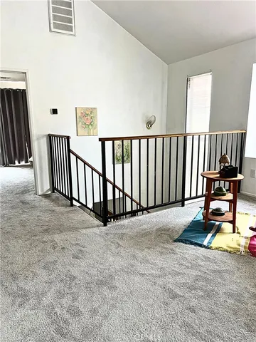 a view of a hallway with wooden floor and windows