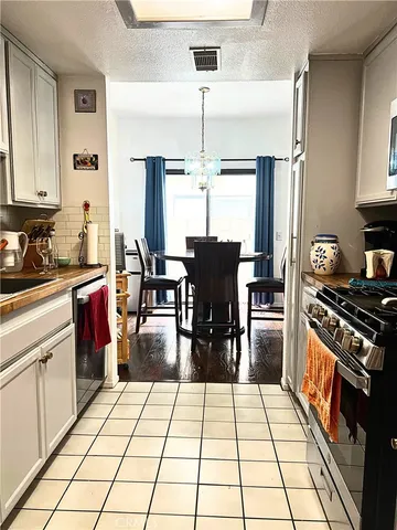 a kitchen with stainless steel appliances kitchen island granite countertop a stove top oven a sink dishwasher and cabinets