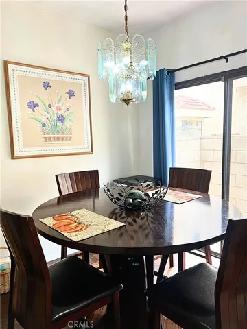 a view of a dining room with furniture a chandelier and wooden floor