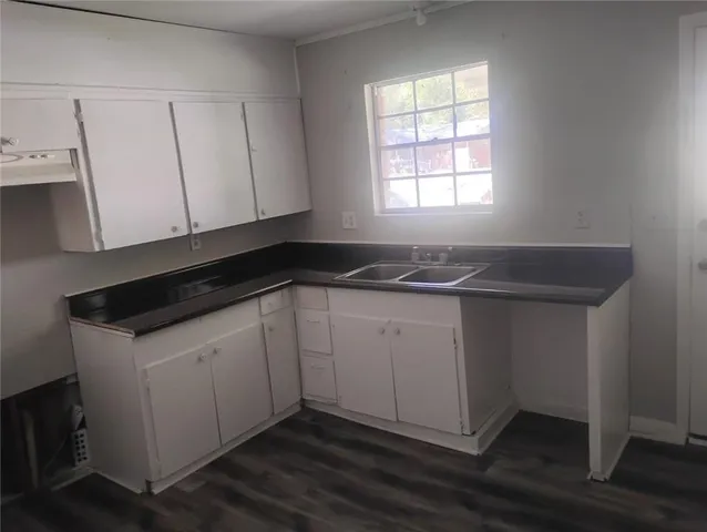 a kitchen with a refrigerator sink and cabinets