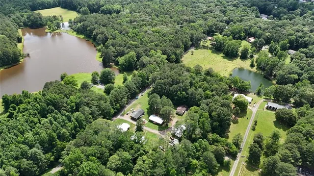 an aerial view of a house with a yard and lake view