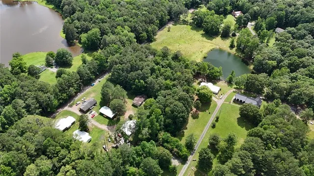 an aerial view of a residential houses with yard and swimming pool