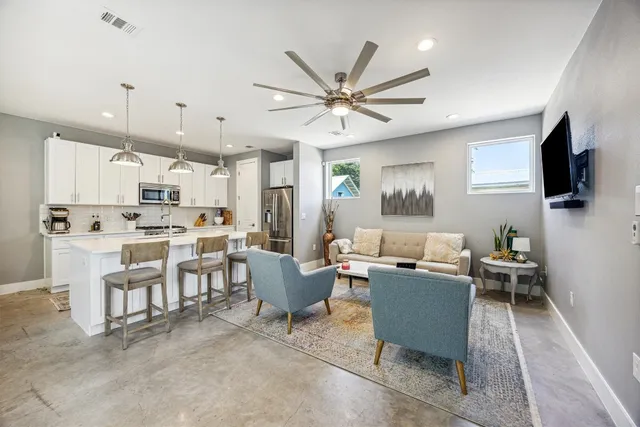 a living room with lots of furniture and kitchen view