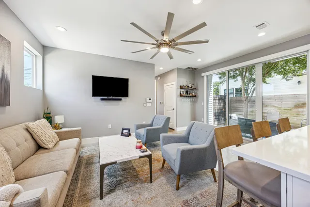a living room with furniture a flat screen tv and a large window