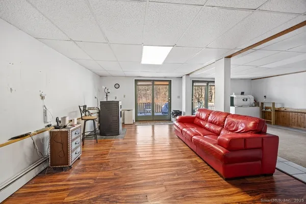a living room with furniture floor to ceiling window and wooden floor