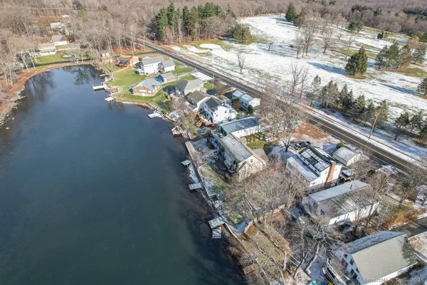 a view of a white house with a large tree