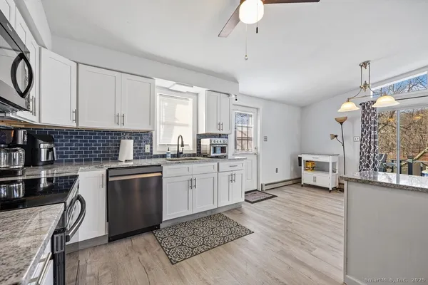 a kitchen with stainless steel appliances granite countertop a stove refrigerator and cabinets