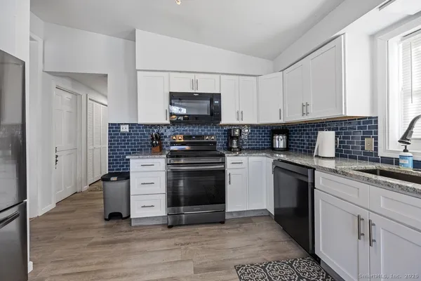 a kitchen with a stove a sink and a refrigerator