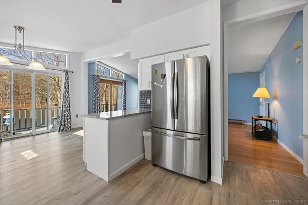 a kitchen with stainless steel appliances wooden floor and refrigerator