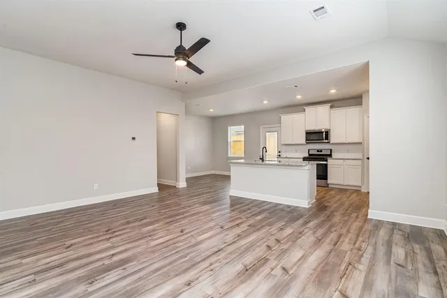 a view of kitchen with refrigerator and wooden floor