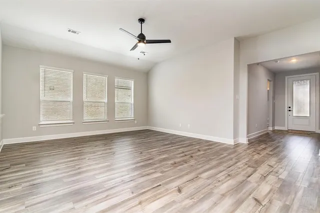 a kitchen with stainless steel appliances granite countertop a stove top oven a refrigerator a sink and dishwasher with white cabinets